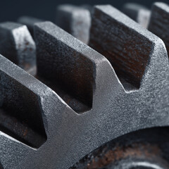 Macro close-up of heavy-duty industrial metal gear teeth with textured steel surface and rustic oxidation highlights.
