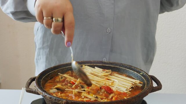 Vegetables and meat are stewed in a deep cast-iron skillet with sauce and spices