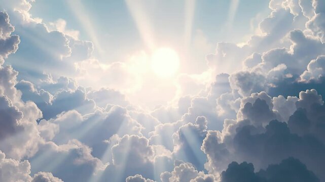 Dramatic sun rays bursting through white clouds blue sky upward view, divine light heavenly atmosphere nature