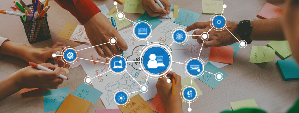 Diverse team members engage in a creative brainstorming session, surrounded by sticky notes and digital connections illustrating collaboration and innovative strategy development. Amity - Powered by Adobe