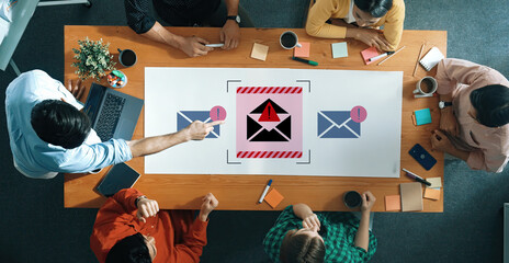 Diverse team members engage in discussion about email security threats, emphasizing awareness and proactive measures in a modern office environment filled with technology. Gantry