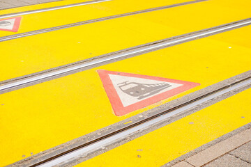 Tram tracks yellow signs, green German trams, European city infrastructure, public transit, European street, barrier free infrastructure, urban municipal transport, European street Frankfurt