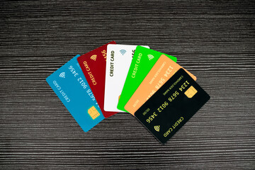 Assorted Credit Cards Fanned Out On Dark Textured Wood Surface Studio Lighting