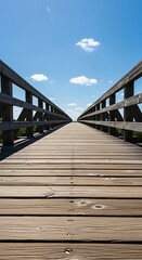 A wooden pathway stretches toward the horizon under a vast blue sky with fluffy white clouds, inviting exploration