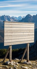 A wooden sign stands atop a rocky landscape, overlooking majestic mountain peaks under a partly cloudy sky