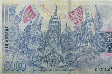 Detailed view of the Czech 5000 Korun banknote featuring intricate blue-hued architectural illustration of Prague Castle, complete with iconic towers, shields, and decorative elements, Czech Republic.