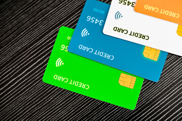Vibrant Credit Cards Green Blue Orange Stacked On Dark Textured Background With Chip Detail