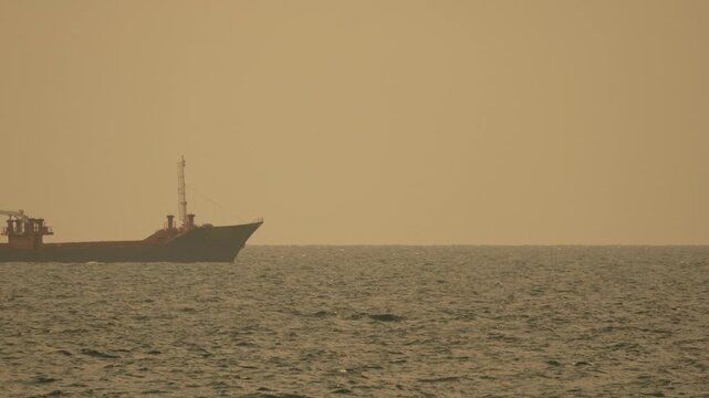 Ship, ocean, freight, large cargo vessel navigates the open sea on a hazy day