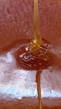 Real organic honey pouring close-up. Abstract food background, vertical video
