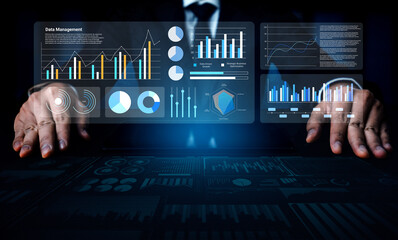 A businessman analyzing data management trends with interactive digital charts and graphs, showcasing technology insights for informed business decisions. Gantry