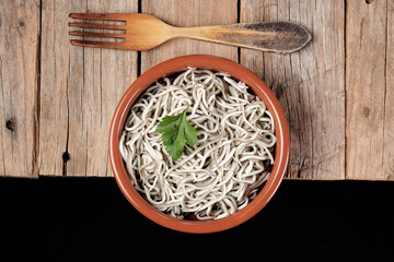 Gulas in a bowl with a wooden fork on a rustic table
