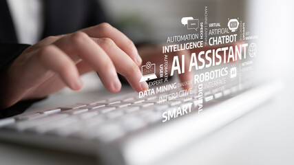 A close-up view of hands typing on a keyboard, surrounded by technology words representing AI,...