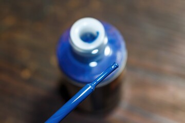 Vivid blue threadlocker bottle, uncapped, with its brush poised for application. Essential industrial adhesive for securing parts