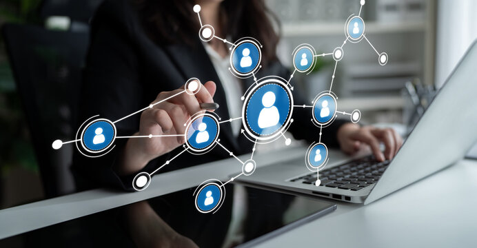 A business professional interacts with a laptop, showcasing a network of digital connections symbolizing collaboration and teamwork in a modern work setting. Tessel - Powered by Adobe