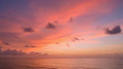 Vibrant pink and orange clouds paint the sky above a tranquil ocean during a beautiful sunset. The serene waters reflect the colorful light, creating a peaceful and picturesque evening scene. - Powered by Adobe