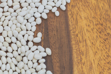 White Beans Scattered on Rustic Wooden Table with Copy Space