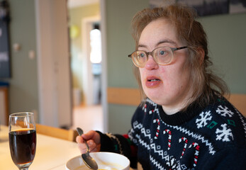 Indoor portrait of a 43-year-old woman with Down Syndrome in a warm family setting © Werner