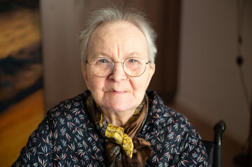 Strong indoor portrait of 87-year-old woman with expressive features, viewed from above
