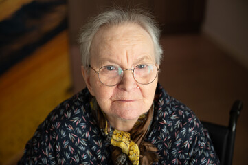 Strong indoor portrait of 87-year-old woman with expressive features, viewed from above
