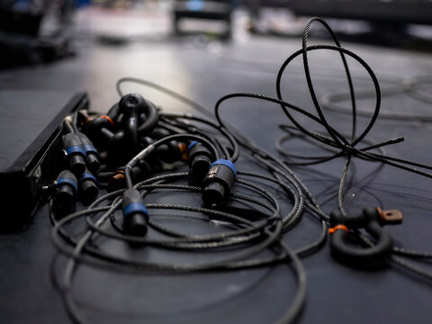 Close-up of professional stage cables with blue connectors on black surface