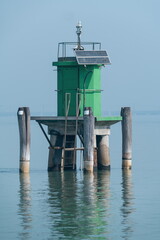 Green Navigation Beacon with Solar Panel in Calm Lagoon Water, Venice, Italy