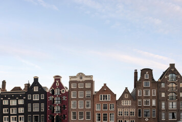 Fototapeta premium Colorful Damrak canal waterfront houses, classic Dutch facades, famous travel destination. For tourist guides, travel blog visuals and social media posts