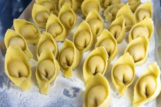 Fresh made not cooked local pasta from Bergamo cappellacci with truffles alla bergamasca, ravioli, pasta on board in local restaurant in Bergamo, Lombardy, Italy, Italian cuisine