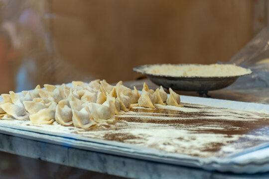 Fresh made not cooked local pasta from Bergamo cappellacci with truffles alla bergamasca, ravioli, pasta on board in local restaurant in Bergamo, Lombardy, Italy, Italian cuisine