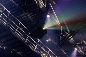 projector creating colorful beam patterns in concert venue