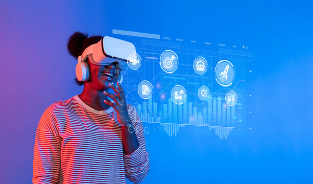 A woman wearing a VR headset smiles as she engages with interactive data visualizations and marketing strategies, representing modern business innovation and analysis. XDMCP - Powered by Adobe