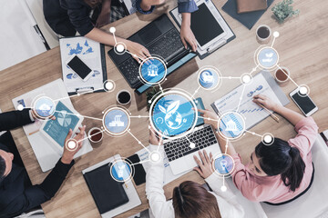 A dynamic scene of professionals engaged in teamwork around a conference table, utilizing laptops and documents to foster collaboration in a vibrant office environment. Tessel