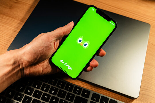 November 23, 2025, Seoul, South Korea - A person holding a smartphone with the Duolingo language learning application logo on the screen.