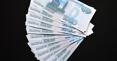 a pack of Russian rubles laid out on a black background. fight against bribes, corruption and...