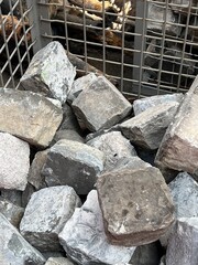 A metal basket full of stone blocks