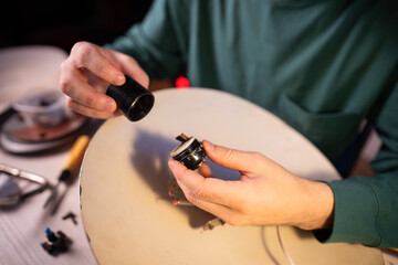 Man technician disassembling vintage electrical lamp at home workshop, crafter disassembled light...