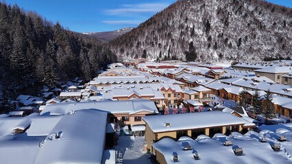 defaultThe view of the Snow Town valley in Harbin, China, is accompanied by a snowstorm, with snow clinging to the rooftops of houses, along with views of the mountains surrounding the village.