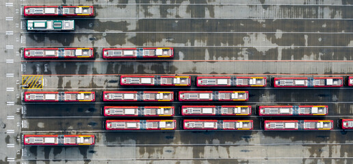 Top down panoramic view of Seattle electrical bus transportation terminal with several buses on wet pavement.