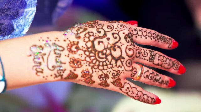 Hand adorned with a henna tattoo form of temporary body art design craft