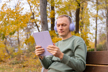 Man enjoying leisure time with tablet in park