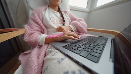Young female engaging with multiple gadgets in moody pink lighting