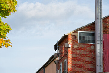 Obraz premium Red brick building with gray pipe and narrow metal stair