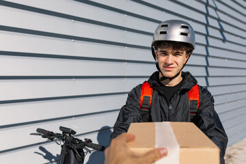 Young delivery boy handing box to man