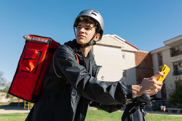 Young delivery boy on an electric scooter