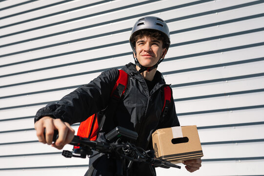 Young delivery boy on an electric scooter