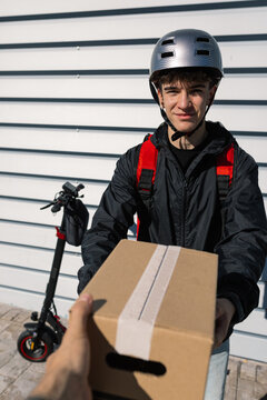 Young delivery boy handing package to a customer
