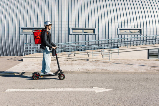 Young delivery boy riding an electric scooter