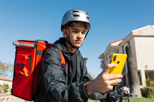 Young delivery boy on an electric scooter with backpack