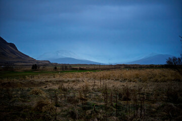 Fototapeta premium Misty Mountain Peaks Over the Fields of Akranes, Iceland
