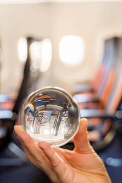 Crystal ball on airplane reflecting seats