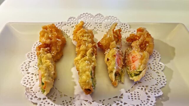 Stuffed fried chicken fillets sliced and served on plate with decorative doily